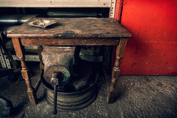 Posacenere su un tavolo di legno grunge in una discarica con vecchi mecani — Foto Stock