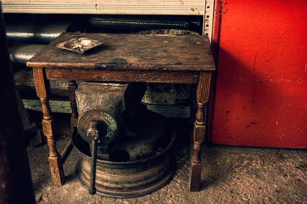 Posacenere su un tavolo di legno grunge in una discarica con vecchi mecani — Foto Stock