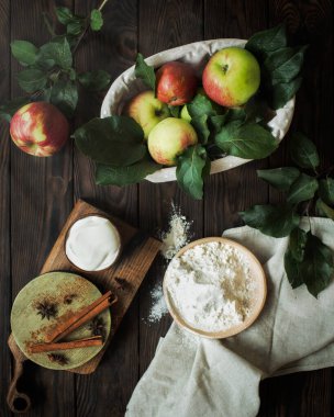 Sonbahar hala hayattır. Elma, tarçın, kahverengi ahşap bir masada yıldız anason. Elmalı turta yapmak için ürünler