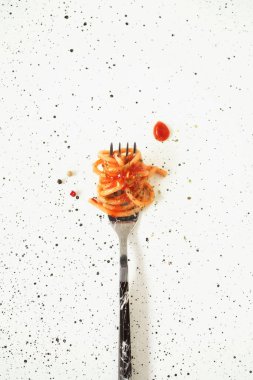 Domates soslu İtalyan makarnası. Çatala sarılı makarna beyaz bir arka planda yatıyor. Çatallı ve baharatlı spagetti. Minimalizm tarzında yemek. İtalyan mutfağı ve kültürü