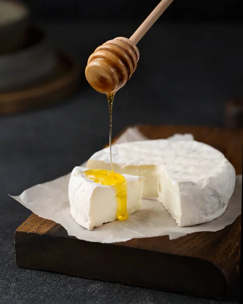 在木板上的奶油奶酪 加蜜的Camembert在奶酪上倒入蜂蜜 涂上一层白糖 法国菜 黑暗背景下的开胃酒 — 图库照片