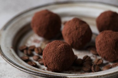 Çikolatalı şekerler. Hafif arka planda nefis bir tatlı. Kahve yer mantarı. Beyaz tabakta tatlılar. Tatlıların makro fotoğrafçılığı.