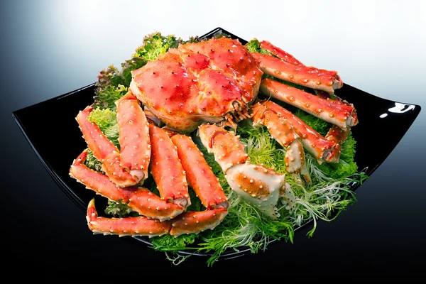 Red king crab served on black square plate