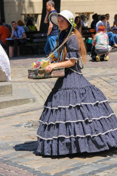 Girl seller with candy dressed in retro clothing in historic cit — Stock Photo, Image