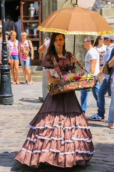 Chica vendedor con caramelo vestido con ropa retro en la ciudad histórica — Foto de Stock