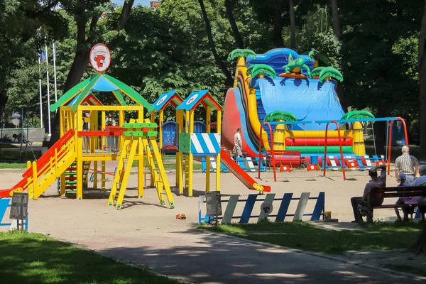 Ludzie z dziećmi na plac zabaw w parku Ivan Franko. Lwów, Wielka Brytania — Zdjęcie stockowe