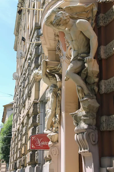 Part of old house with atlas on both sides of the entrance in hi — Stock Photo, Image