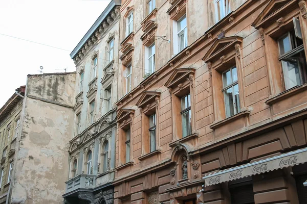 Fachada de edificio antiguo con estatuas en el centro de la ciudad. Lviv, Reino Unido — Foto de Stock