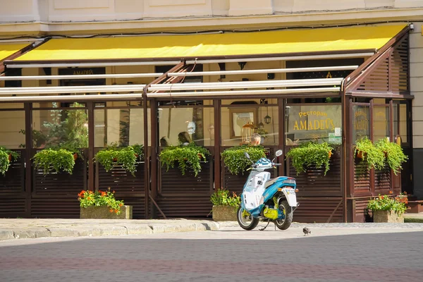 Parkerade moped nära uteservering på restaurang Amadeus i histo — Stockfoto