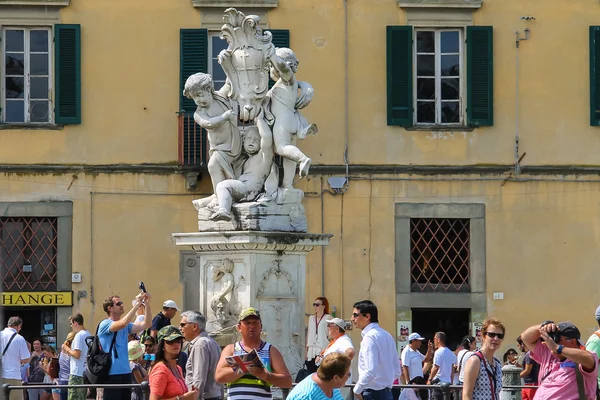 Turistas cerca de la fuente con ángeles en la Piazza dei Miracoli en —  Fotos de Stock