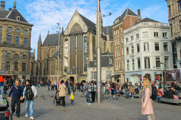 Туристы, идущие по площади Дам в Амстердаме, Нидерланды — стоковое фото