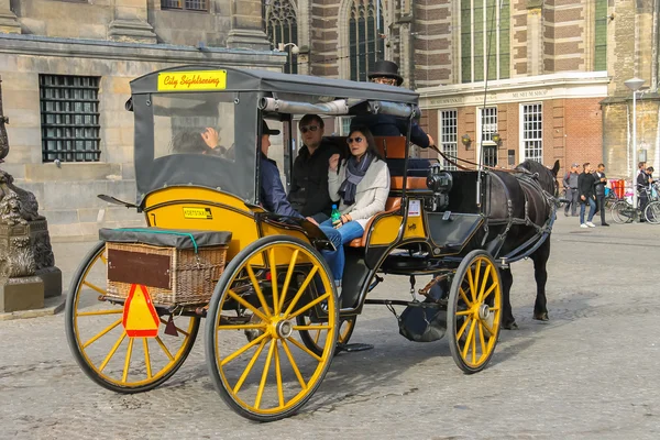 Transporte com para turistas na Praça Dam em Amsterdã — Fotografia de Stock