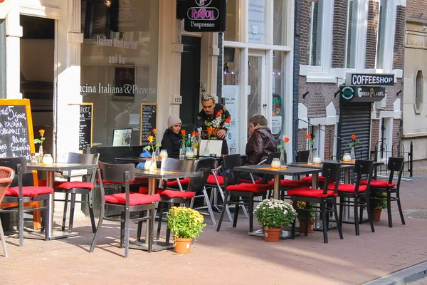 Menschen ruhen sich in Outdoor-Café in Amsterdam, den Niederlanden — Stockfoto