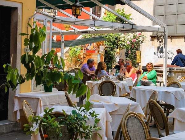 I turisti riposano ai tavoli in un caffè all'aperto a Venezia — Foto Stock