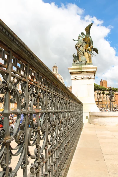 Lattice fence and a statue of the monument to Victor Emmanuel II — Stock Photo, Image