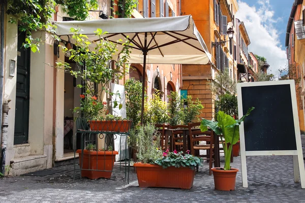 Mesas de café ao ar livre em uma rua estreita em Roma, Itália — Fotografia de Stock