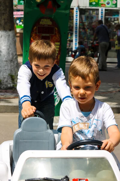 Niños en la zona de juegos montando un coche de juguete. Nikolaev, Ucrania — Foto de Stock