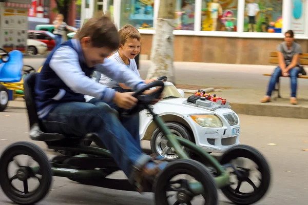 Niños en la zona de juegos montando un coche de juguete. Nikolaev, Ucrania — Foto de Stock