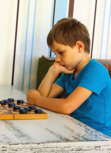 Chico pensativo durante un juego de damas — Foto de Stock