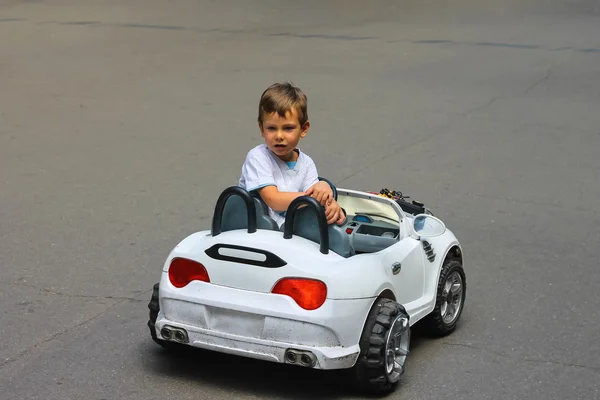 孩子在公园里骑着一辆玩具车 — 图库照片