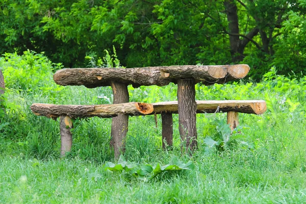 Mesa y bancos de troncos están en el bosque — Foto de Stock