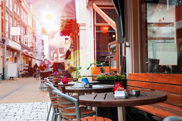 Rue urbaine avec un café pittoresque aux rayons du soleil — Photo