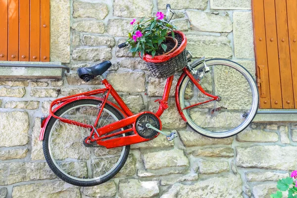 Cykel på væg med blomster i kurv - Stock-foto