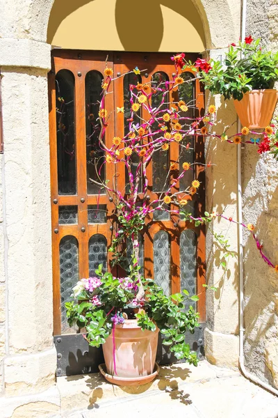 Arranjo de flores decorativas perto da porta da casa italiana — Fotografia de Stock