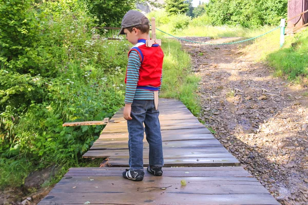 Маленький мальчик с деревянным мечом в парке — стоковое фото