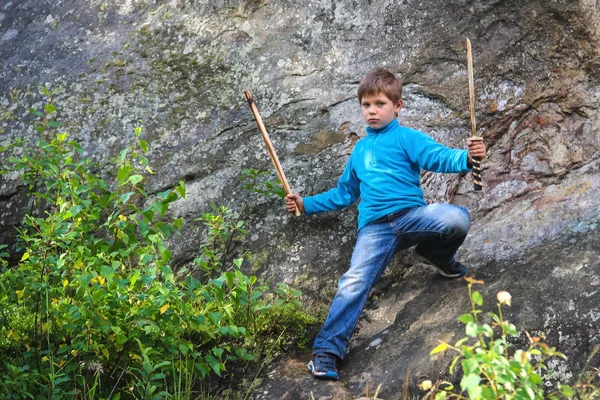 Серйозна дитина з дерев'яним мечем на камені — стокове фото