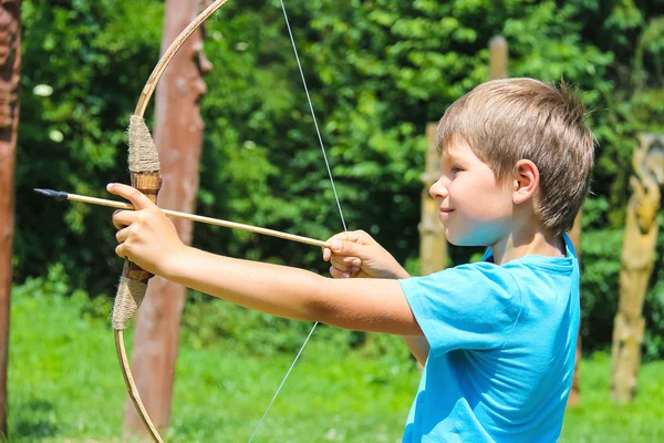 The kid shoots a bow in the park — Stock Photo, Image