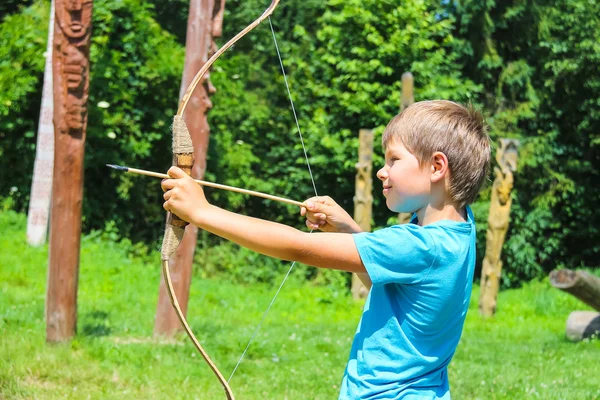 The kid shoots a bow in the park — Stock Photo, Image