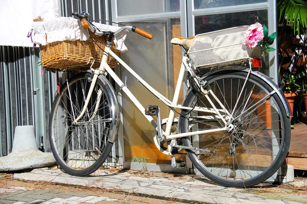 Bicicleta con canasta de mimbre cerca de la pared — Foto de Stock