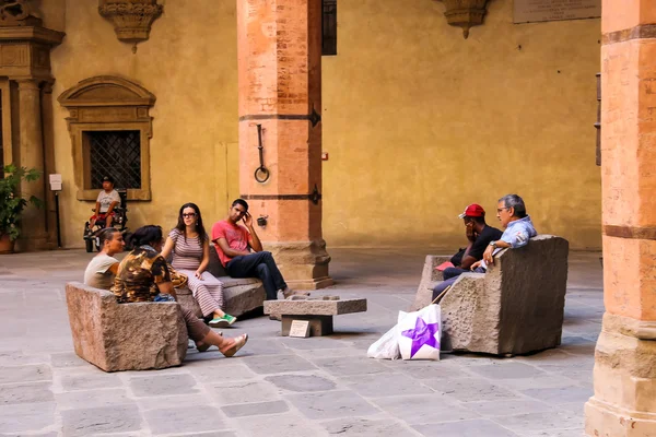 Personas descansando en un banco de piedra en el patio del Palazzo —  Fotos de Stock