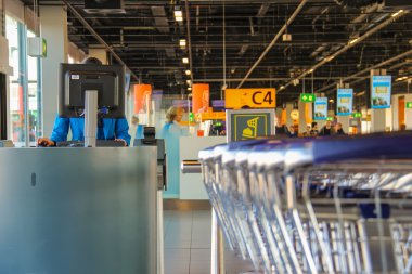 Interior of Amsterdam Airport Schiphol. Employee working on a co