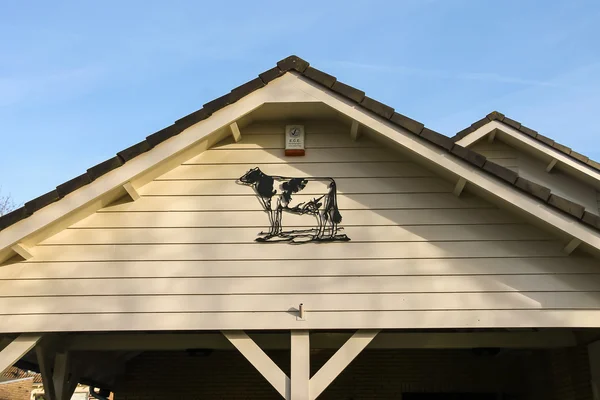 Metal bas-relief depicting a cow decorated gable house in Meerke — Stock Photo, Image