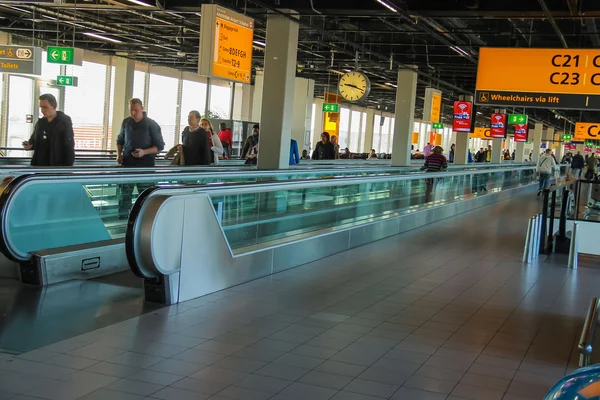 Interiorul aeroportului Amsterdam Schiphol. Pasagerii pe o curvă lungă — Fotografie, imagine de stoc