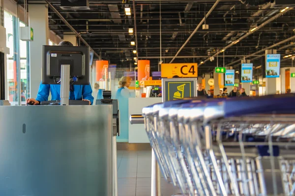 Interior of Amsterdam Airport Schiphol. Employee working on a co — Stock Fotó