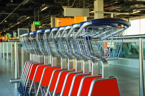 Row of luggage carts in hall of the airport — Stock Photo, Image