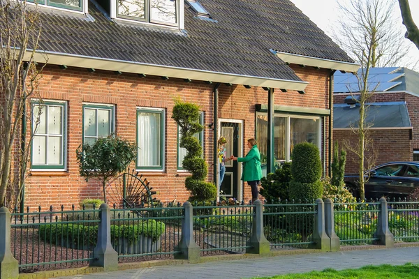 Two women chatting on the doorstep in the Dutch town of Meerkerk — Stock Photo, Image