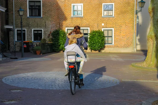 The woman and little girl riding a bicycle in the Dutch city Mee — Stock Photo, Image