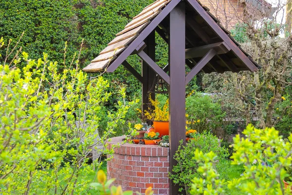 The picturesque well in the spring garden — Stock Photo, Image