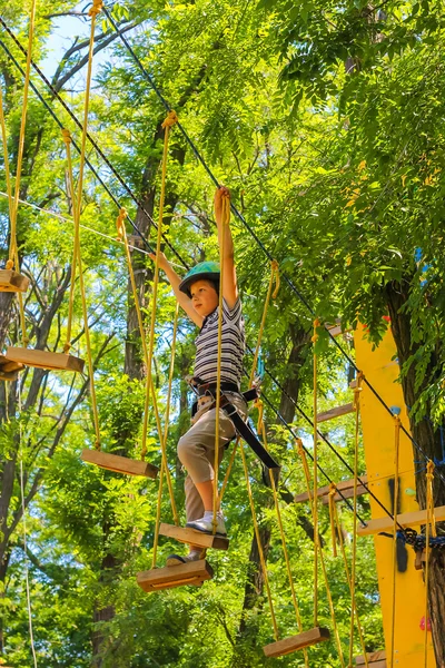 Fiatal, boldog gyermek fiú adventure parkban, biztonsági berendezések — Stock Fotó