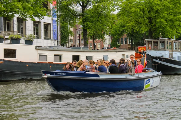 Ludzie w łodzi na wycieczki po kanałach Amsterdamu — Zdjęcie stockowe