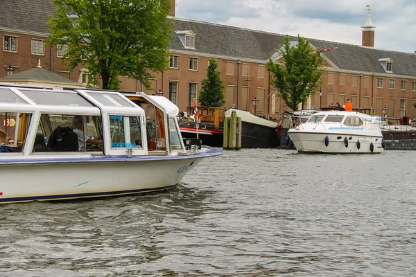 Orang-orang di perahu yang sedang melakukan tur di kanal Amsterdam — Stok Foto