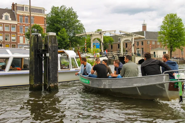 Ludzie w łodzi na wycieczki po kanałach Amsterdamu — Zdjęcie stockowe