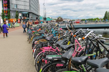 People near the bicycle parking on the waterfront canal in Amste