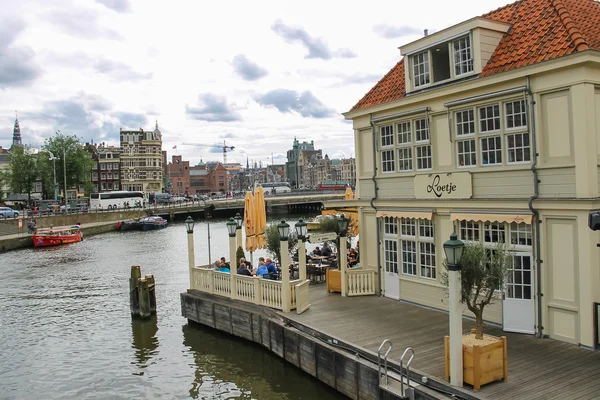 Les gens près du café sur le front de mer du canal à Amsterdam — Photo