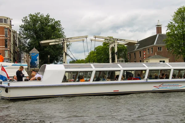 Az emberek a csónakban túrák a csatornákon, az Amszterdami — Stock Fotó