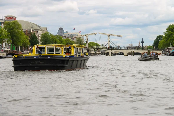 Люди в лодке на экскурсии по каналам Амстердама — стоковое фото